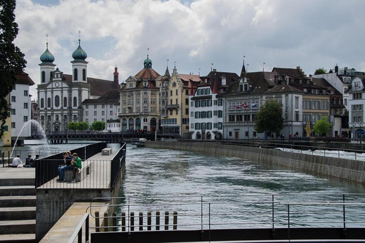 a group of people sitting on a bench next to a river