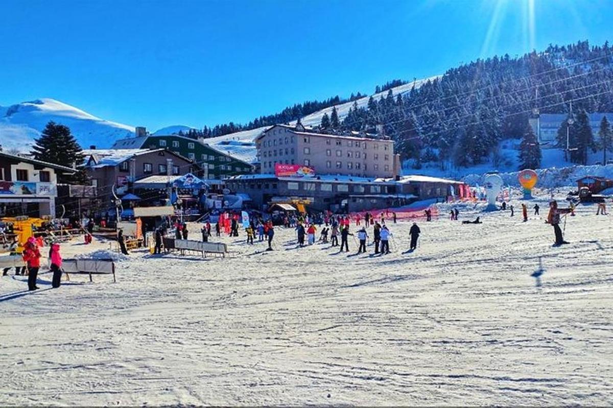 un grup de persones dempeus a la neu en una pista d'esquí