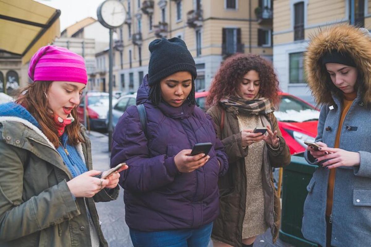 egy csoport nő a mobiltelefonjait nézegeti