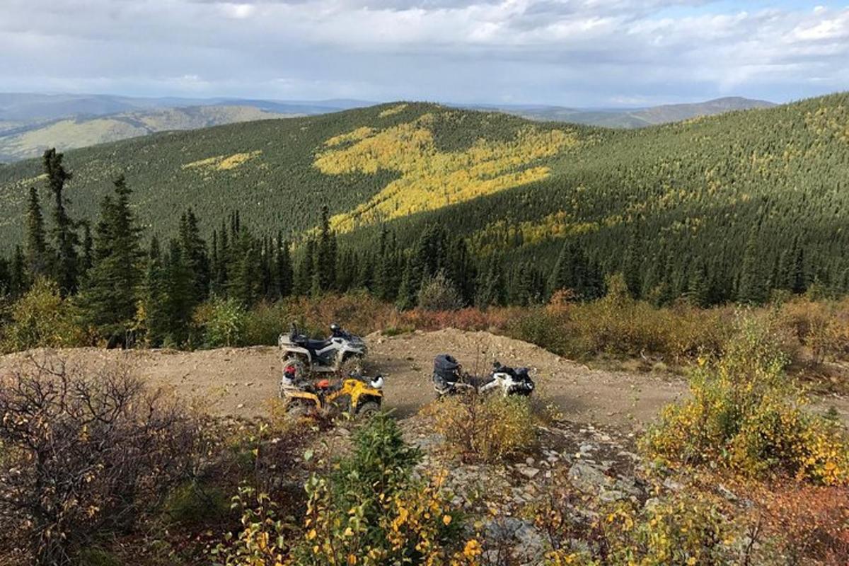 a group of motorcycles parked on a hill in the mountains