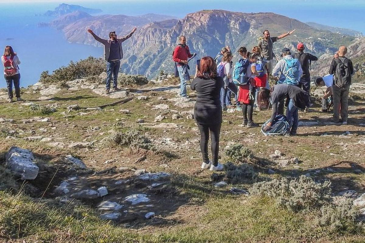 μια ομάδα ανθρώπων που στέκονται στην κορυφή ενός βουνού