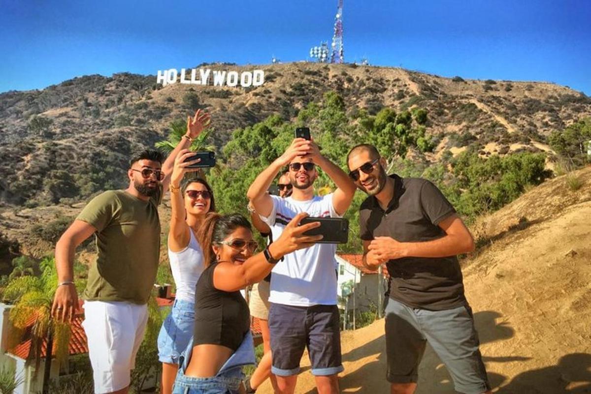Skupina lidí pózujících před hollywoodským nápisem