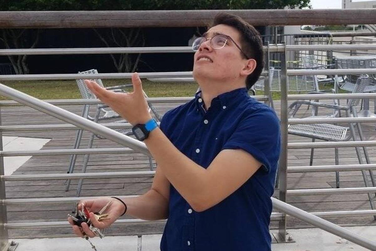 a man in glasses is pointing at a bird