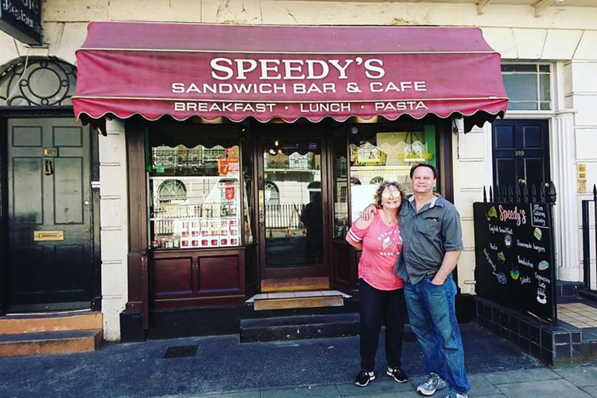 Un hombre y una mujer de pie frente a un restaurante.