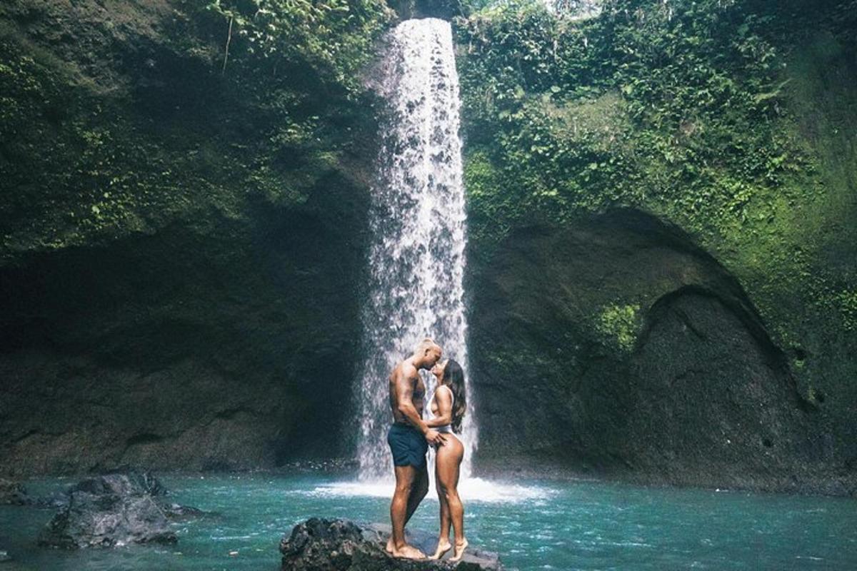 seorang lelaki dan wanita berdiri di hadapan air terjun