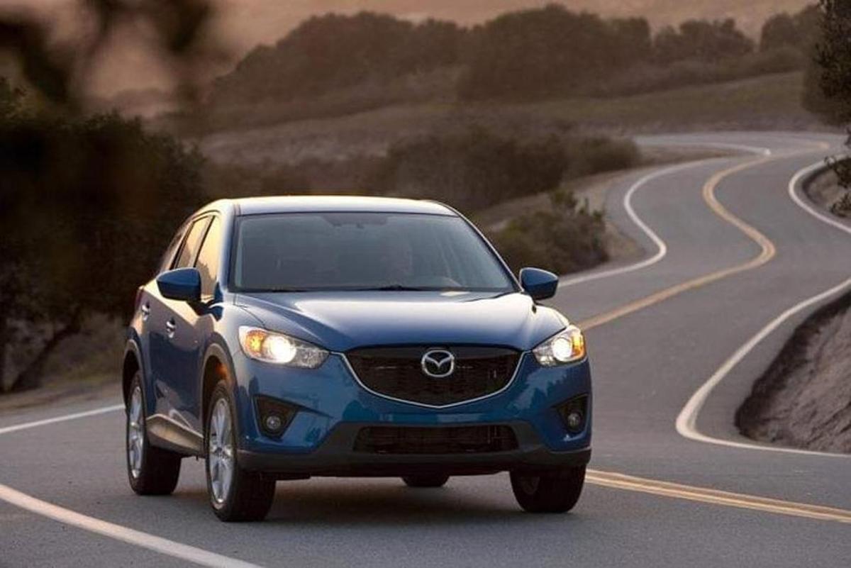 en blå Mazda CX-klone som kjører nedover en vei