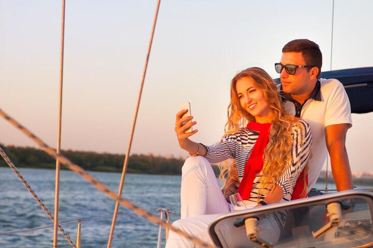 un home i una dona asseguts en un vaixell mirant un telèfon mòbil