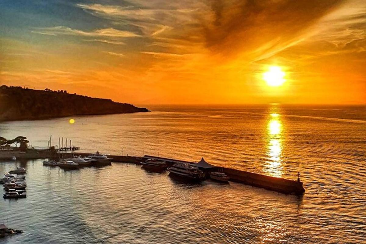 matahari terbenam di atas pelabuhan dengan bot di dalam air