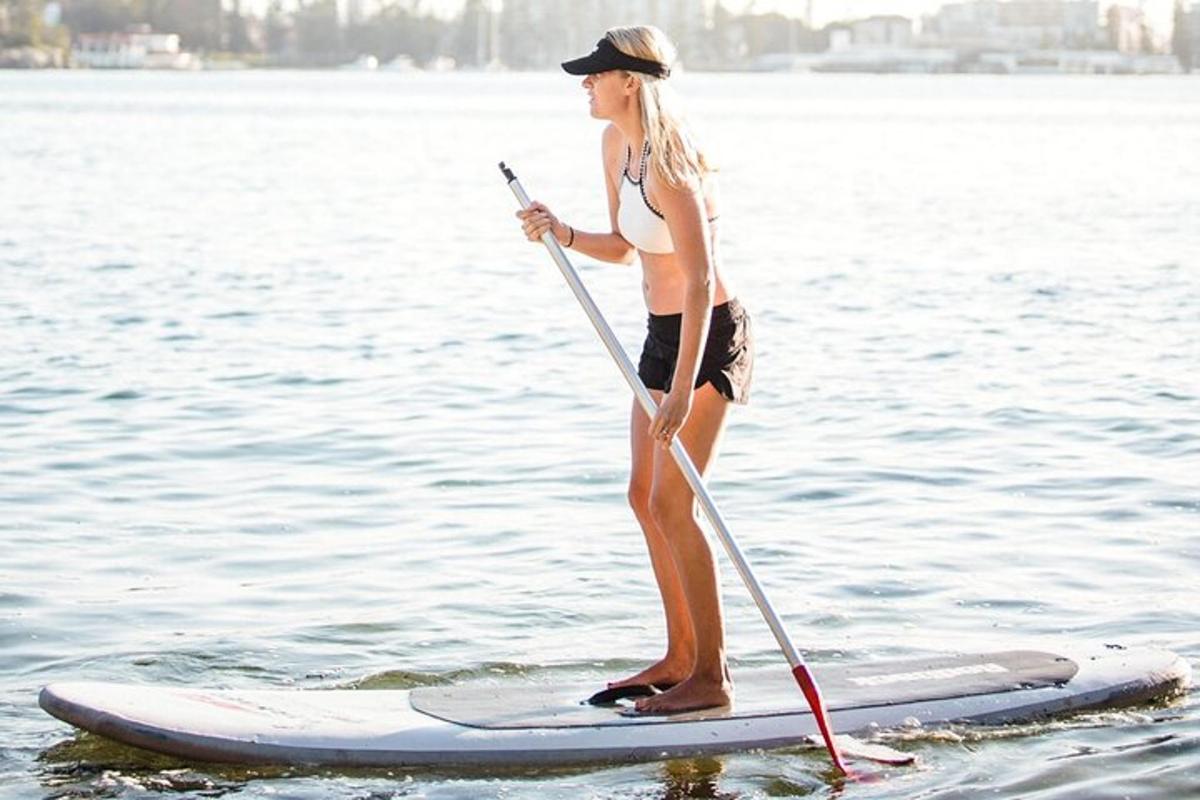 žena stojící na paddleboardu ve vodě