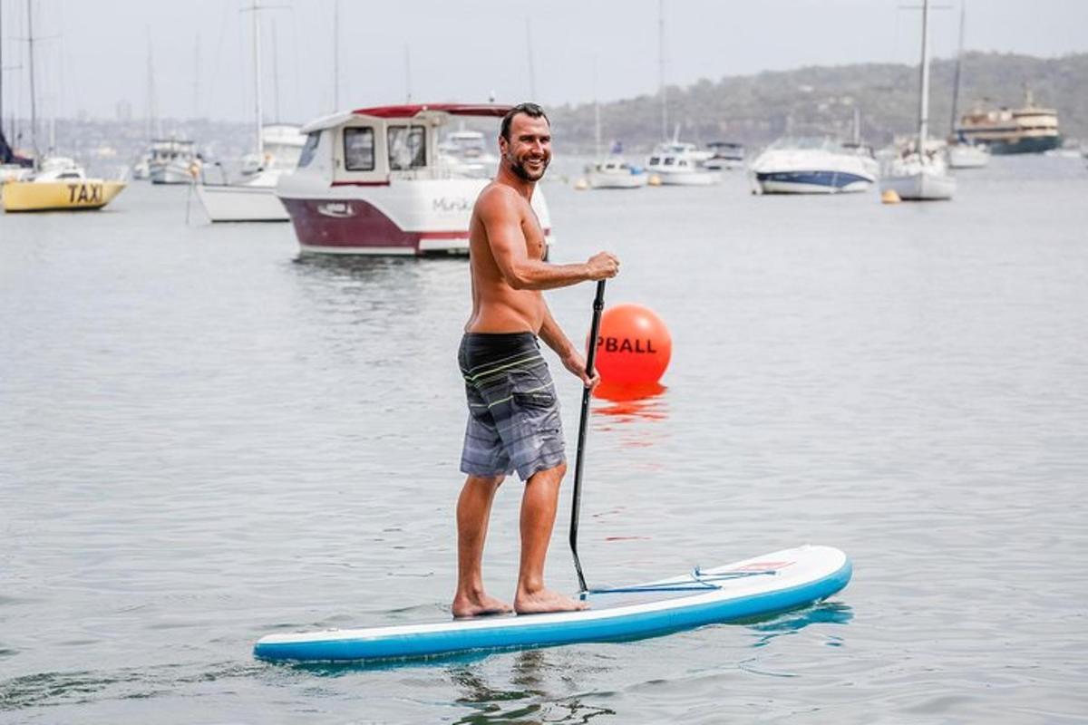muž stojící na paddleboardu ve vodě