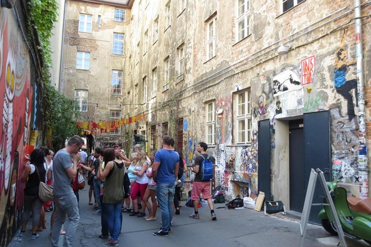 eine Gruppe von Menschen steht auf einer Straße mit Graffiti