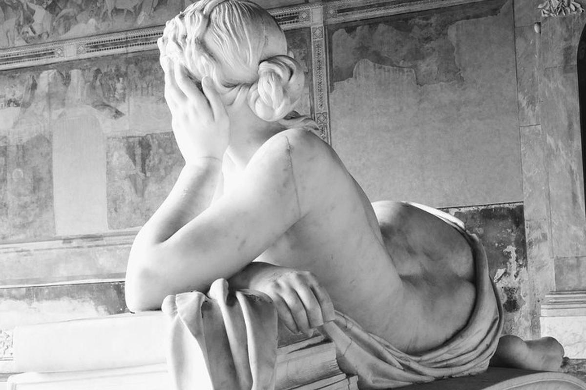 uma estátua de uma mulher sentada em uma mesa