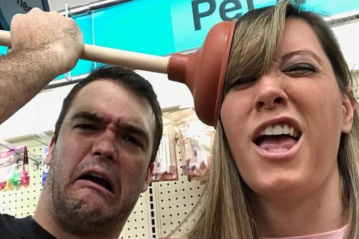 um homem em pé ao lado de uma mulher com um taco de beisebol na cabeça