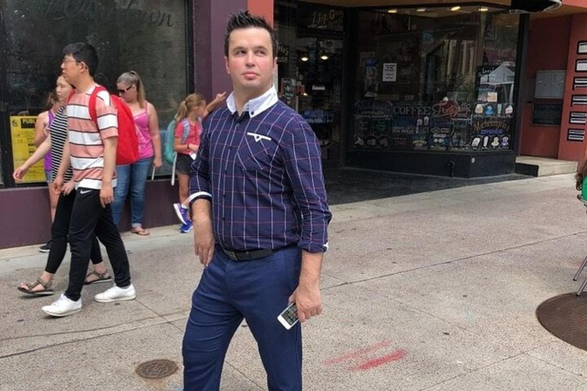 um homem caminhando pela rua com um celular