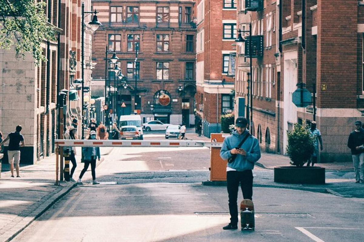 muž stojící na městské ulici se skateboardem