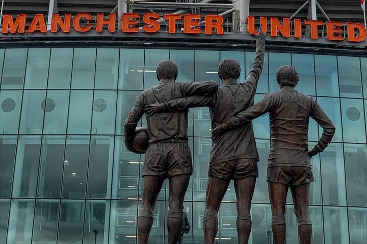 Socha tří mužů před budovou Manchesteru United