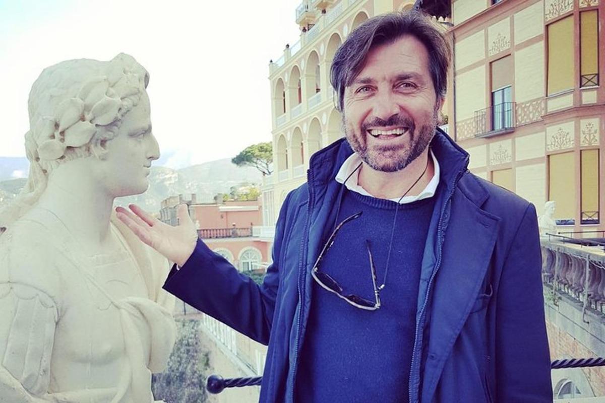 um homem está parado ao lado de uma estátua
