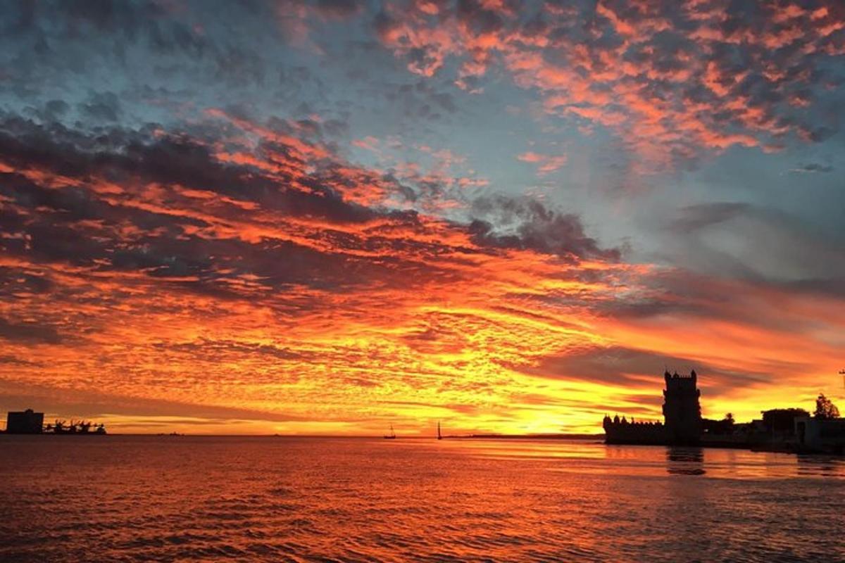 un tramonto sull'acqua con una torre dell'orologio