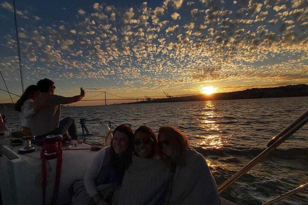 un gruppo di persone sedute su una barca al tramonto