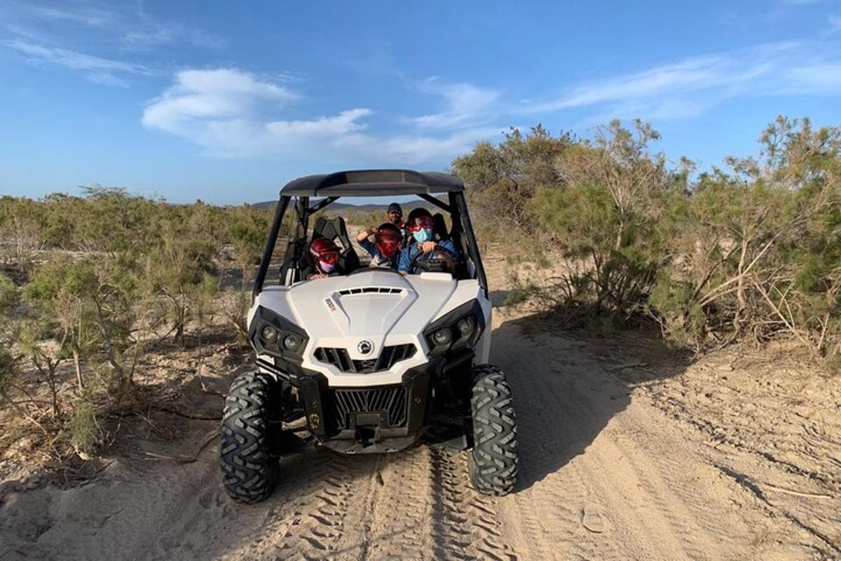 um grupo de pessoas andando de quadriciclo em uma estrada de terra