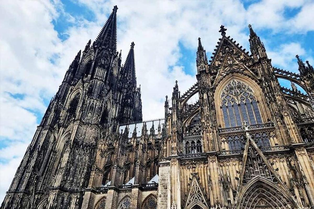 a large cathedral with a clock tower on a cloudy sky