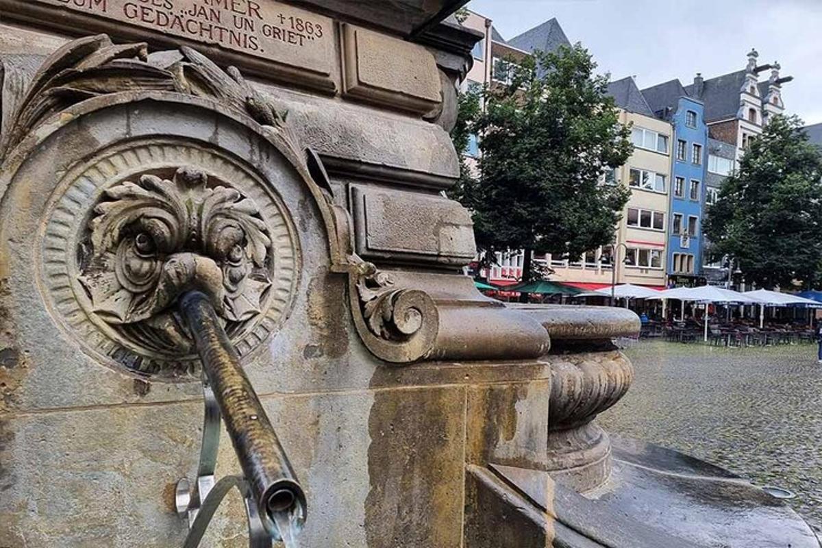 a fountain with a water hose attached to a building