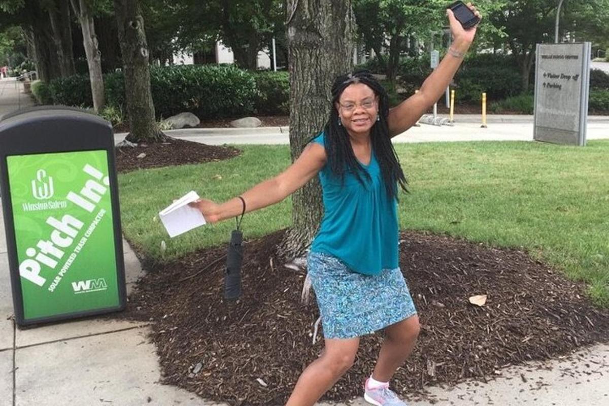 a woman is standing next to a parking meter