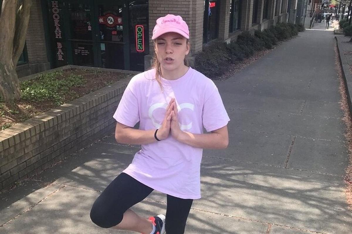 una giovane donna con un cappello rosa sta facendo yoga