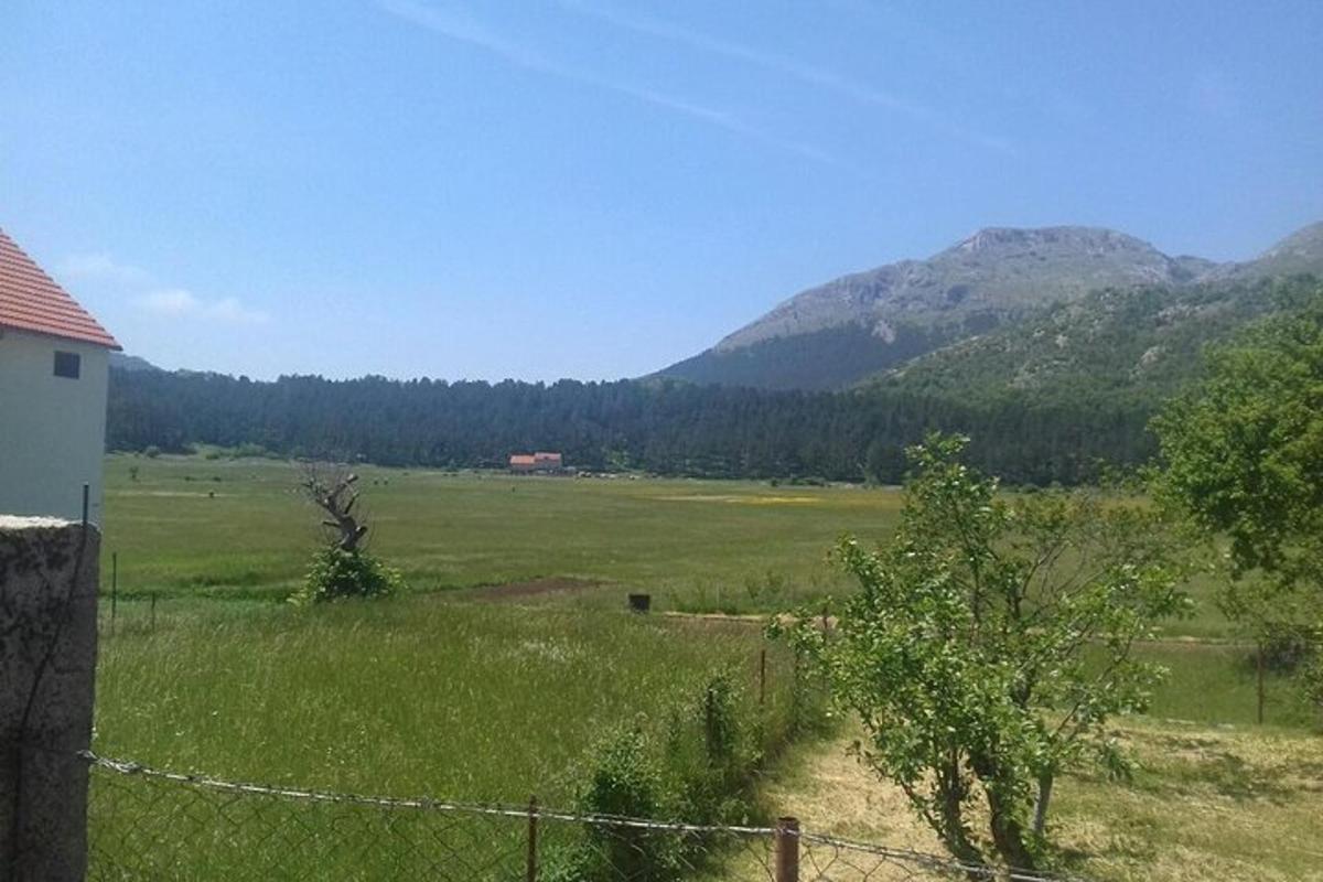 ένα χωράφι με φράχτη και βουνά στο φόντο
