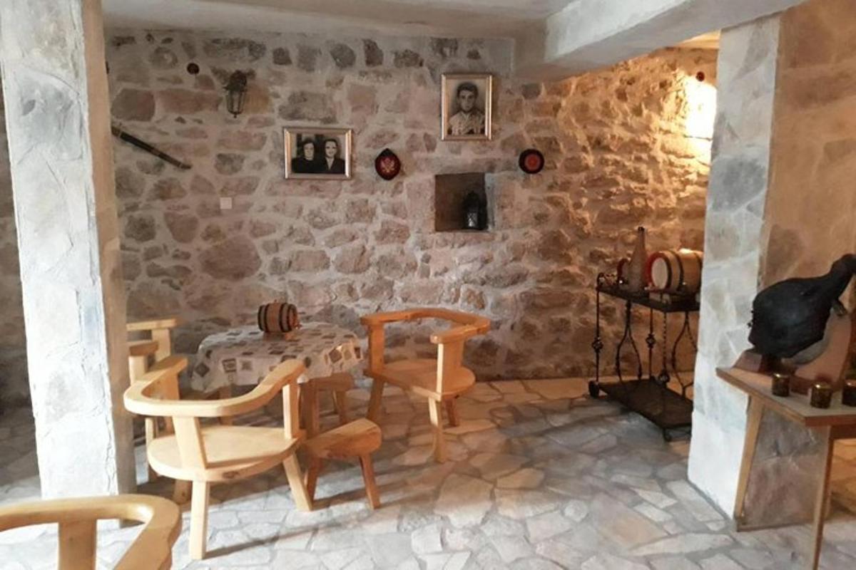 ένα δωμάτιο με τραπέζι και καρέκλες και πέτρινο τοίχο
