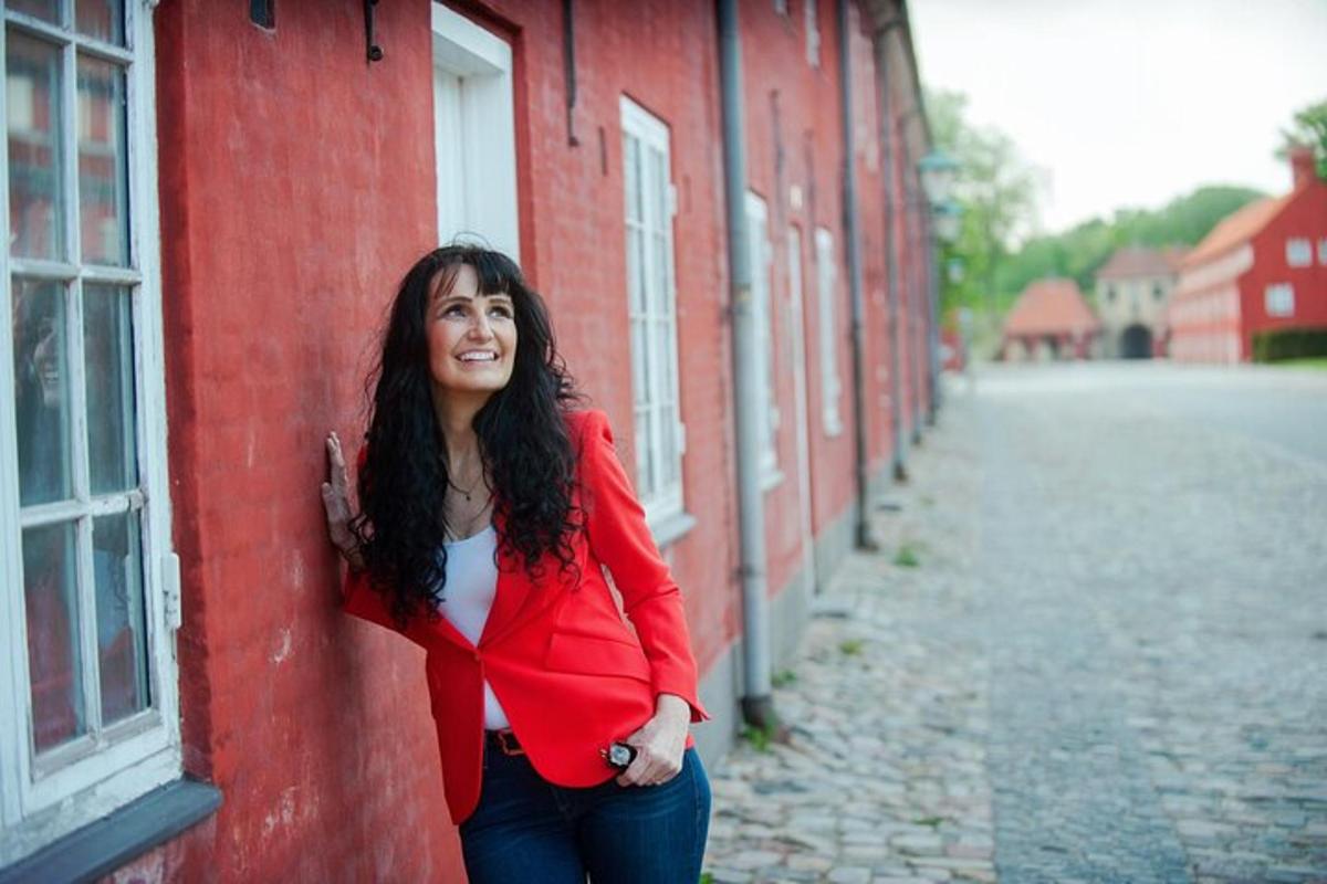 žena stojící vedle červené budovy