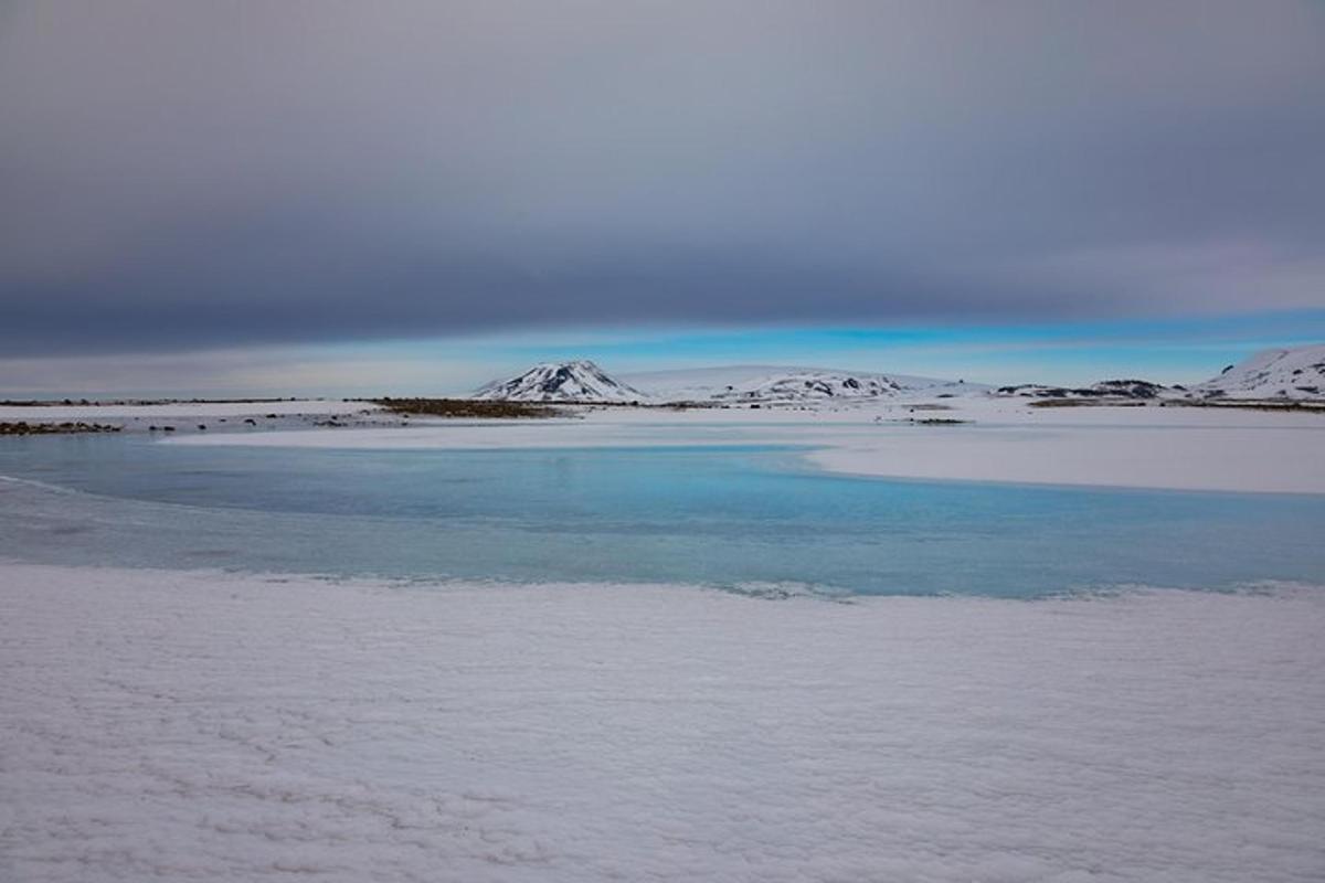 a body of water with snow covered mountains in the background