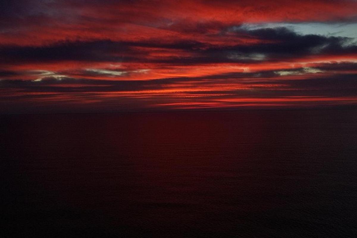 sončni zahod nad oceanom z rdečim nebom