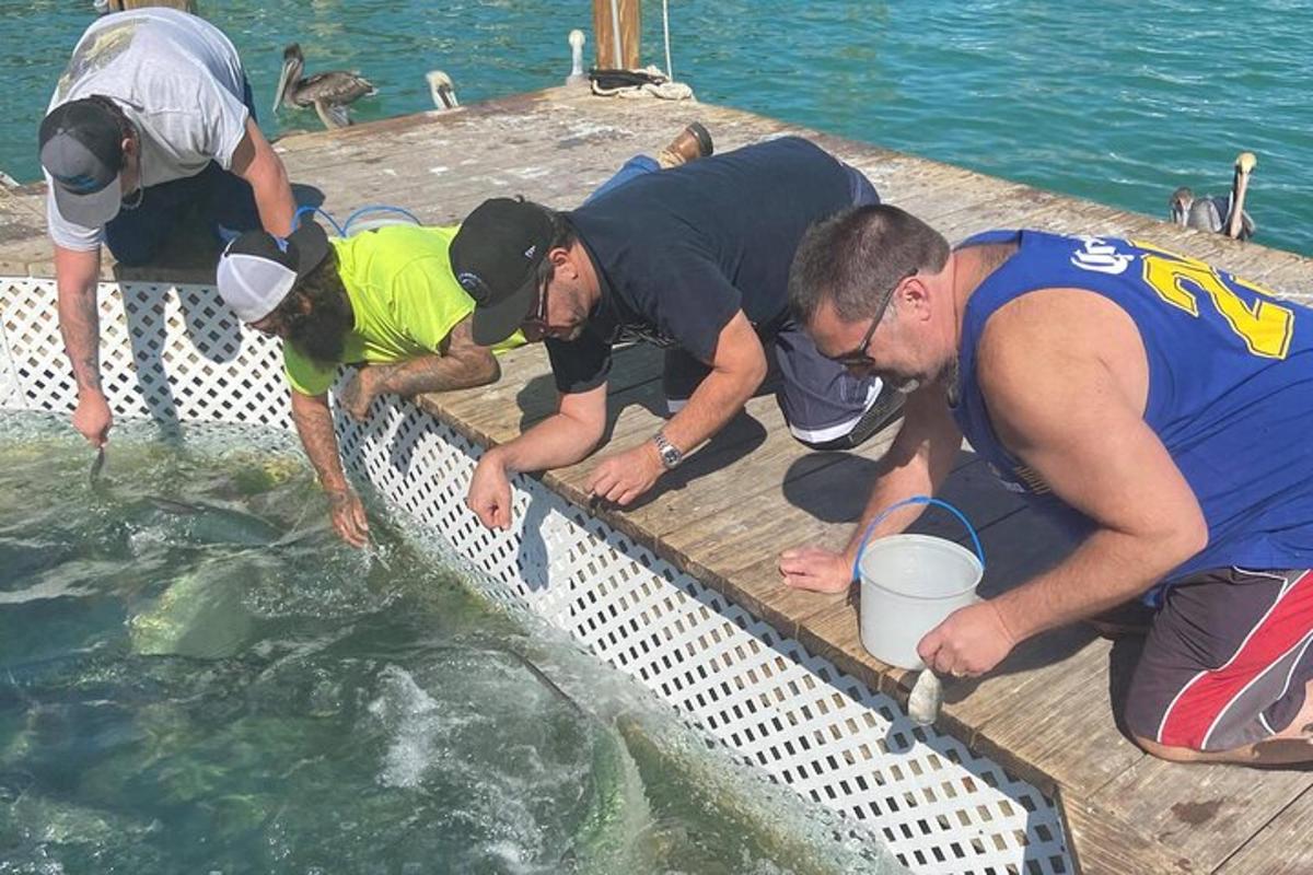 Un grupo de hombres de pie alrededor de un cuerpo de agua.