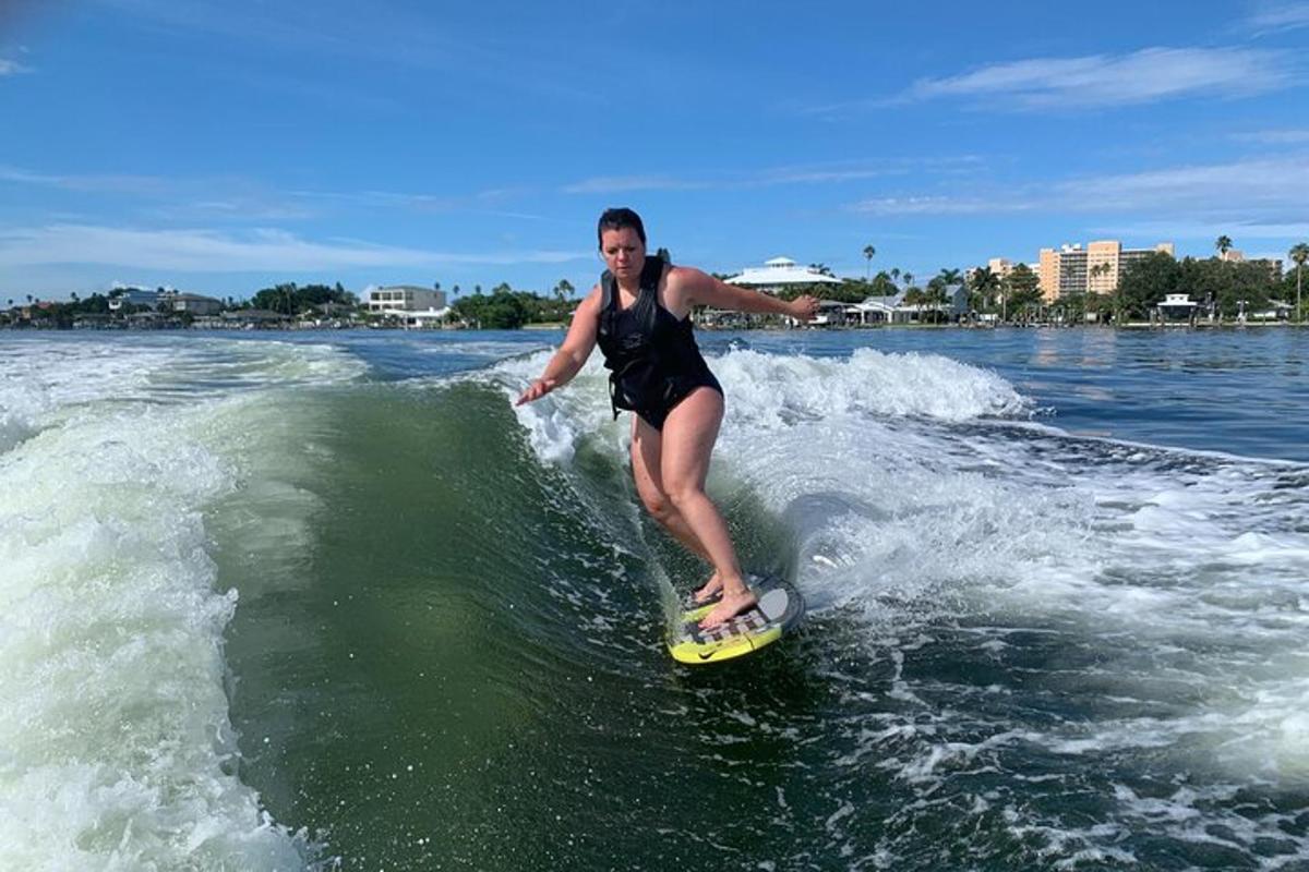 una dona cavalcant una onada sobre una taula de surf a l'aigua