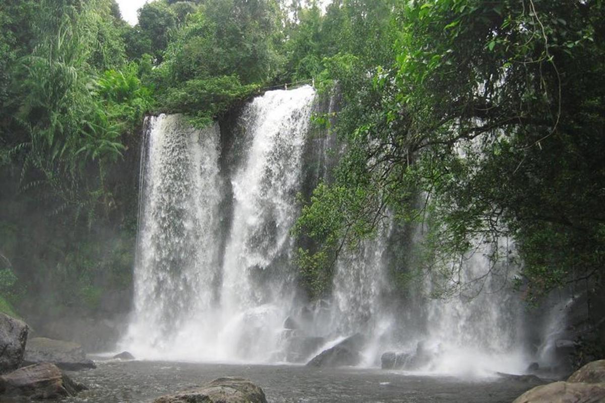 uma cachoeira no meio de um rio com árvores