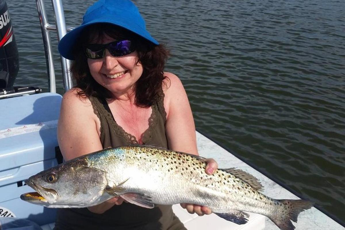 a woman holding a fish on a boat