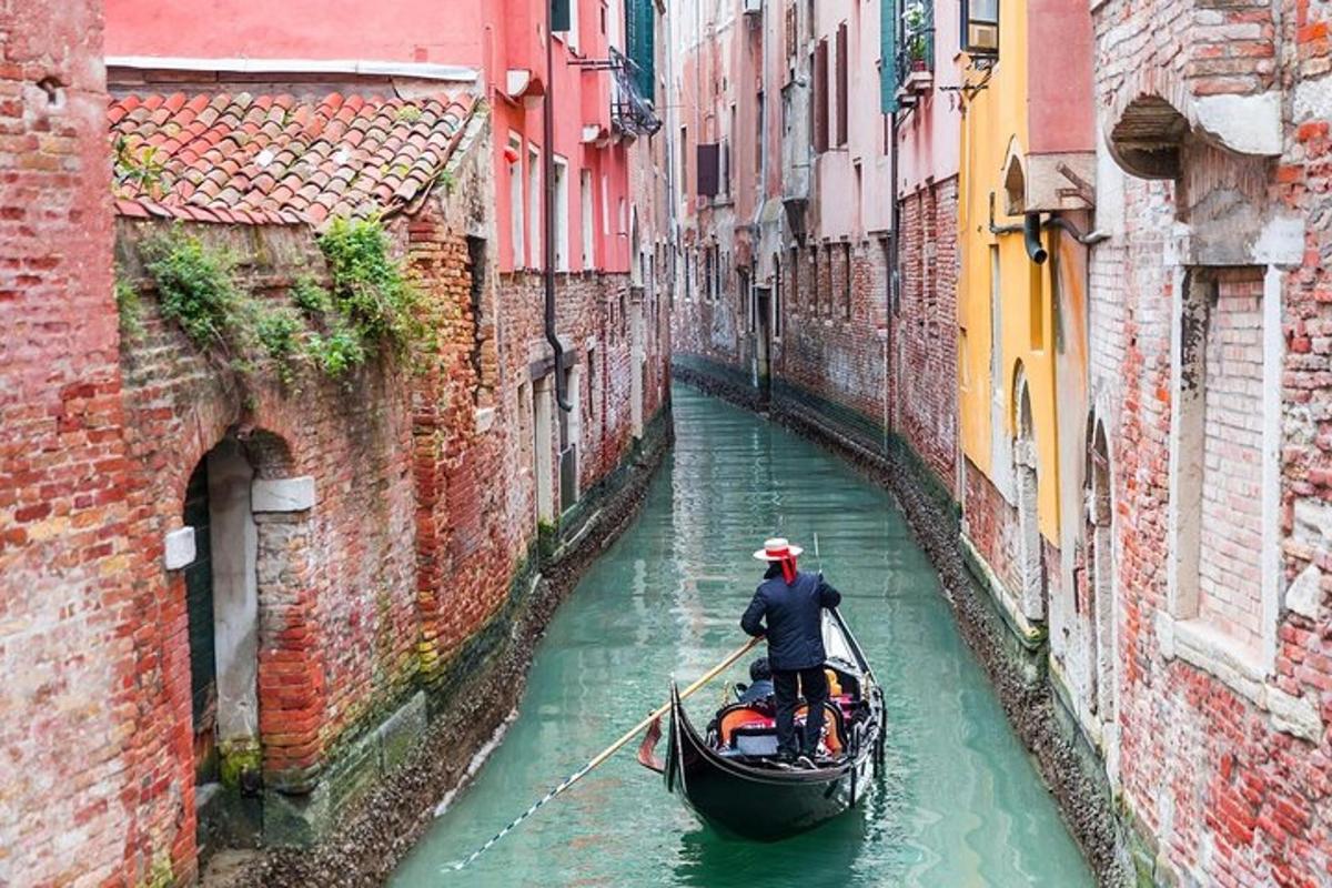un uomo in una gondola in un canale tra gli edifici