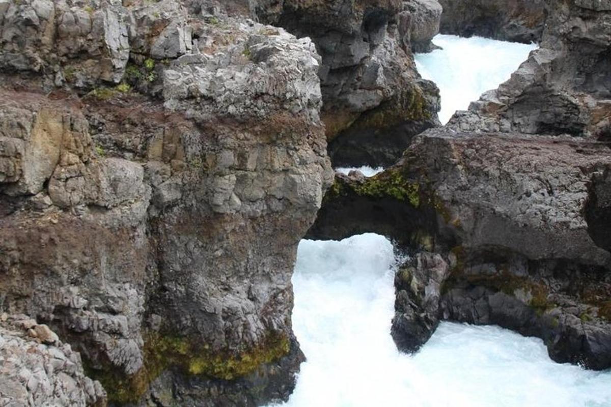á með snjó á fjallshlíð