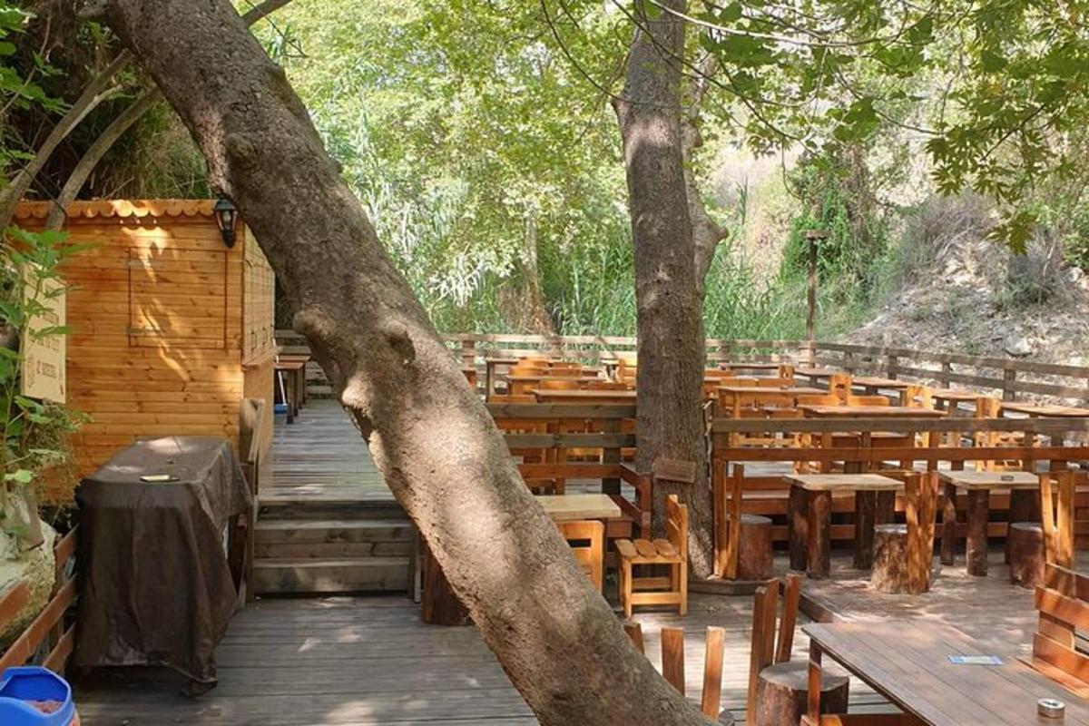 ένα δωμάτιο με ξύλινα τραπέζια και παγκάκια και ένα δέντρο