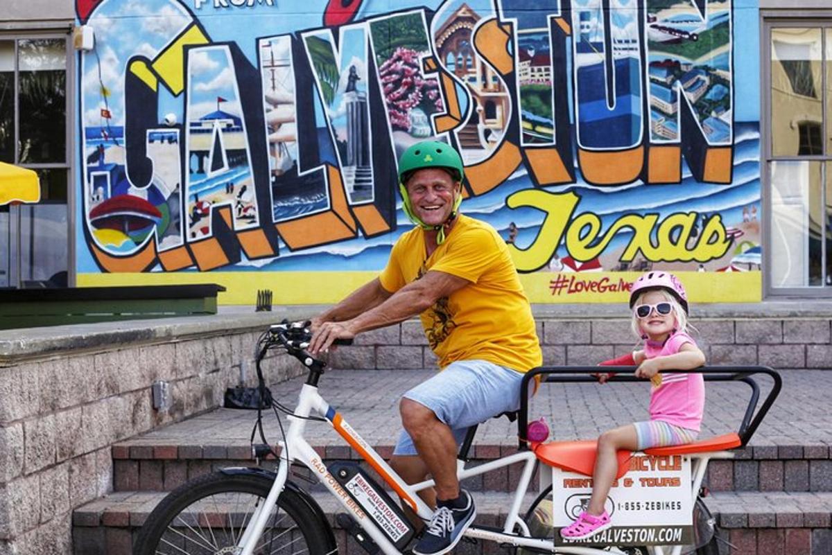 a man and a little girl sitting on a bike