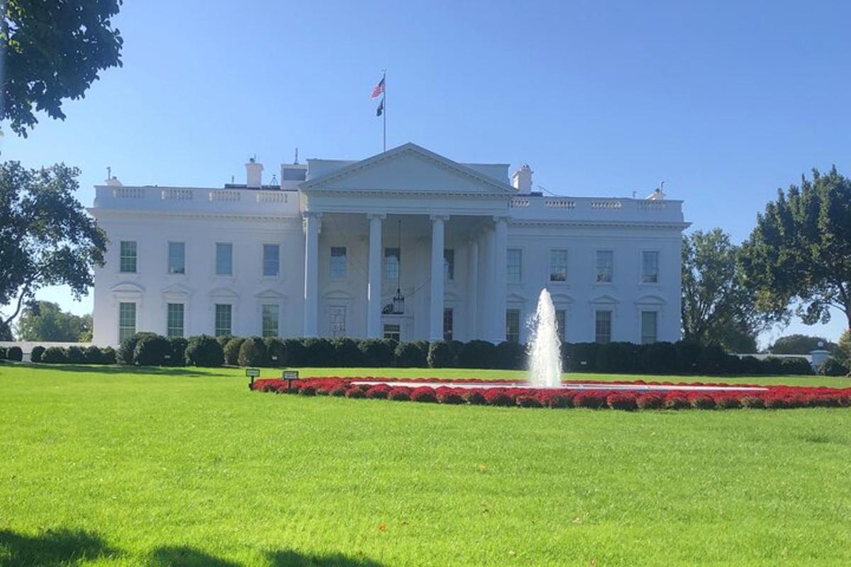 una casa blanca con una fuente delante de ella