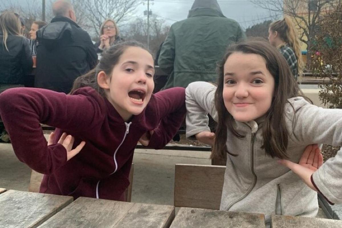 duas jovens posando para uma foto em uma mesa