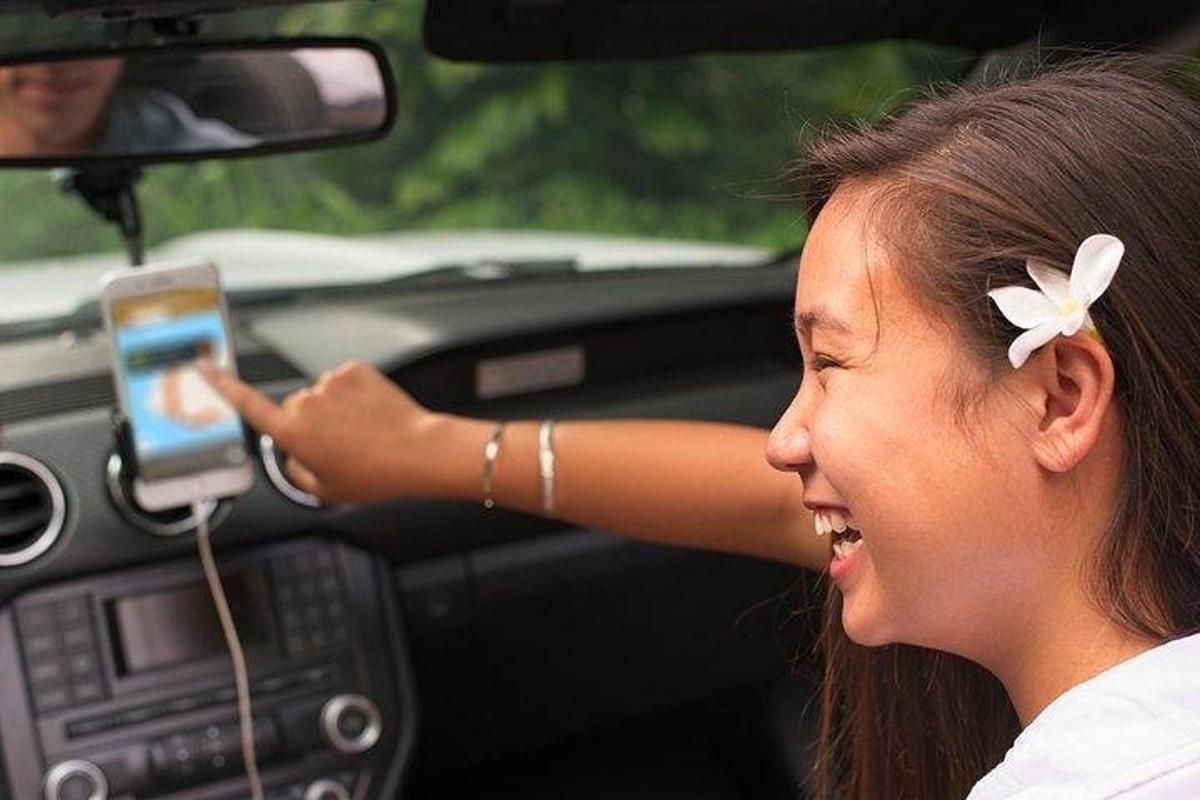 a young girl holding a cell phone in a car