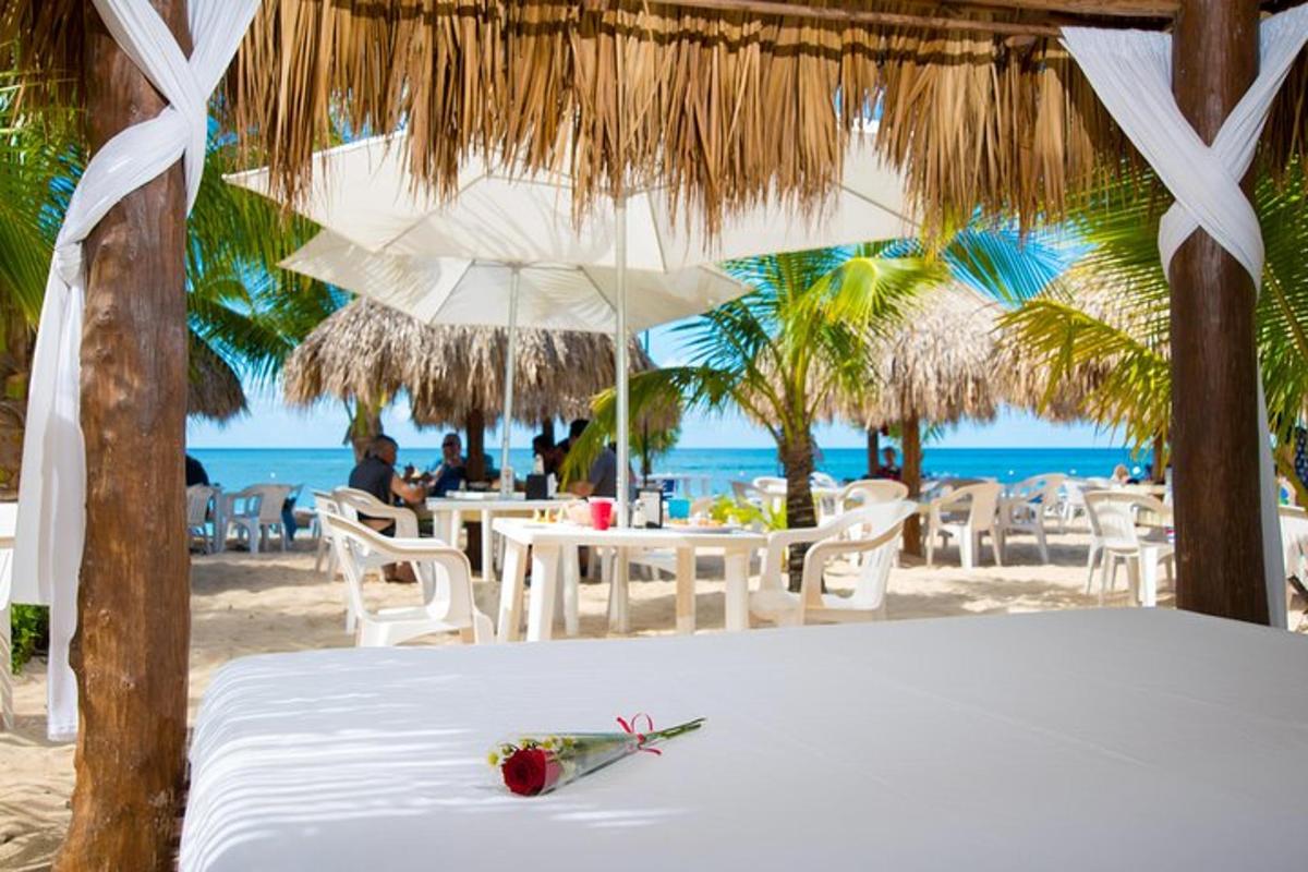 a bed on the beach with a table and chairs