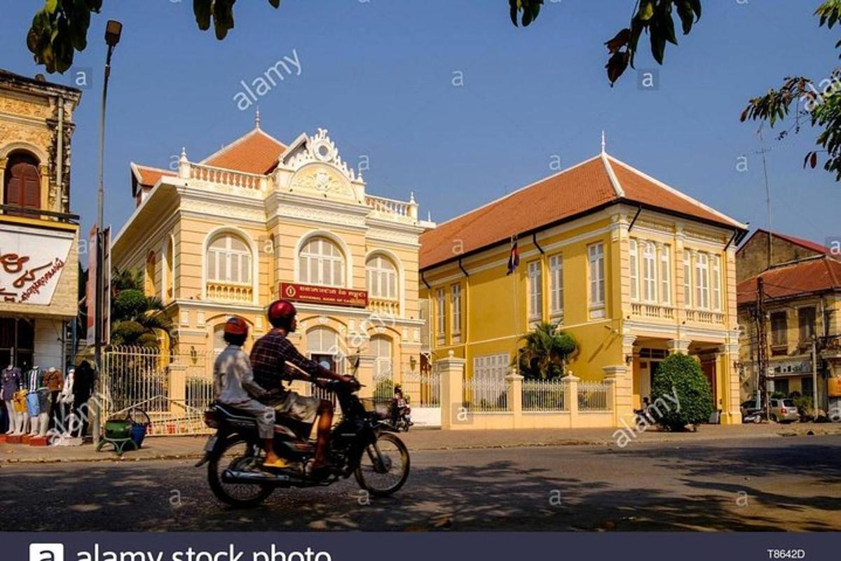 dve osebi, ki vozita motor pred rumeno stavbo