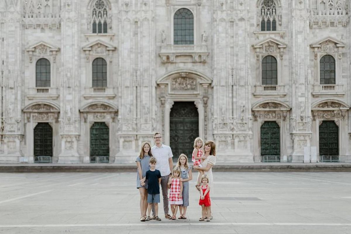 en familie poserer for et bilde foran en bygning