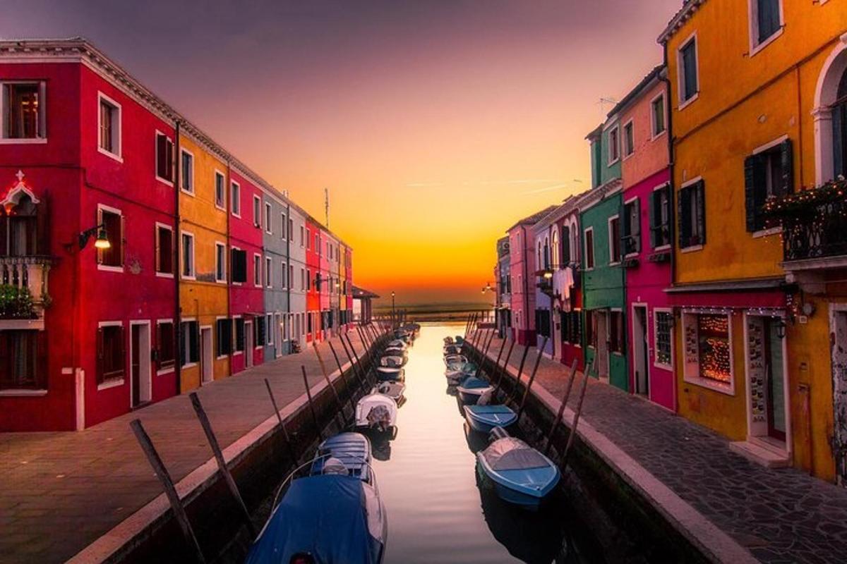 un gruppo di barche in un canale con edifici colorati