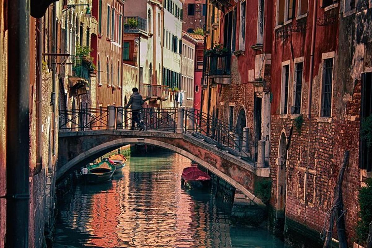 un uomo che cammina su un ponte sopra un canale
