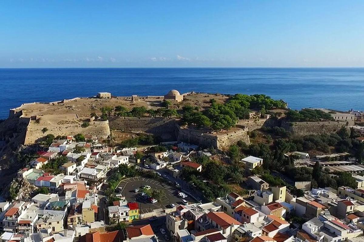 an aerial view of a village on a hill near the ocean